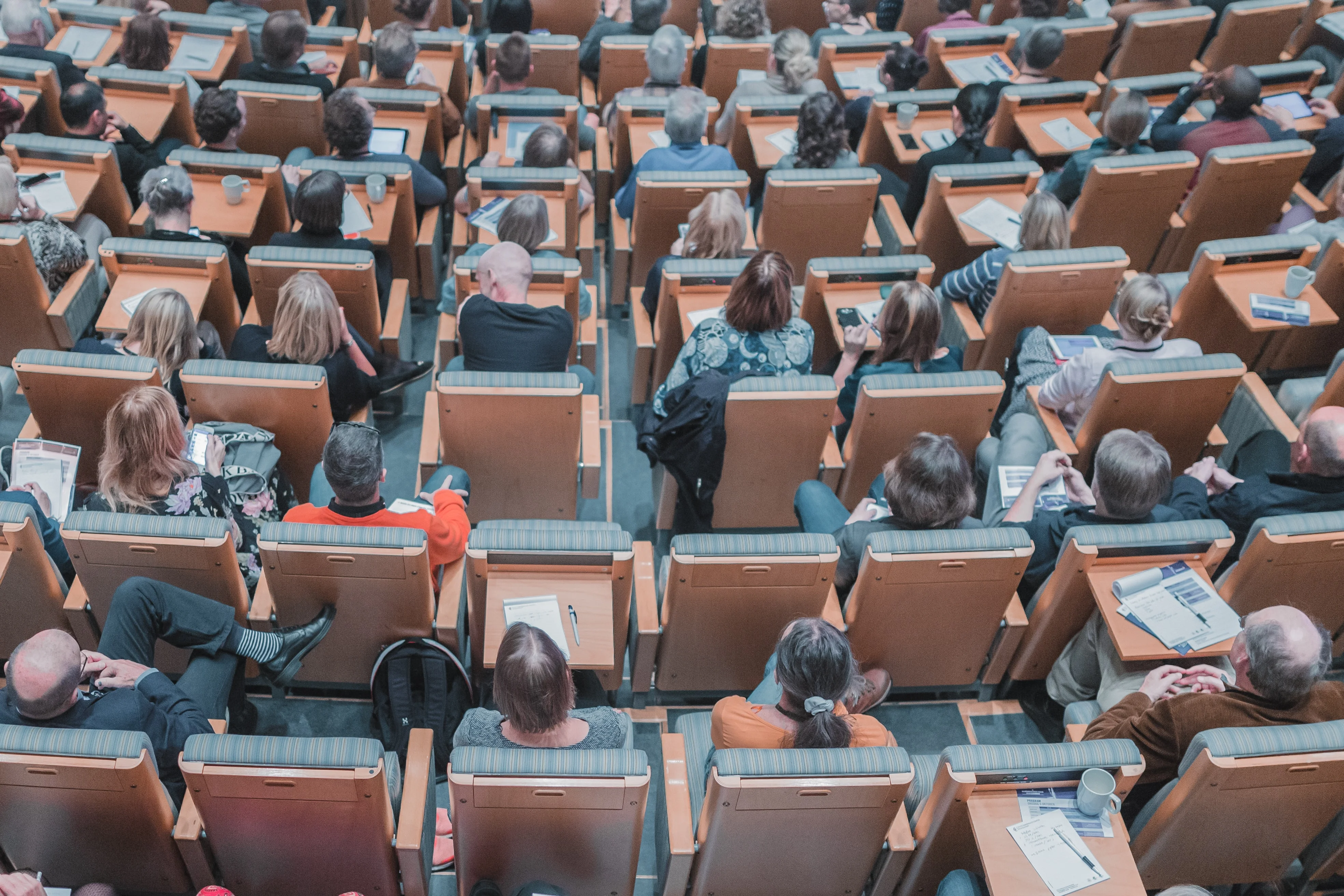 Photo of an overhead view of a college classroom, as students listen to a lecture.