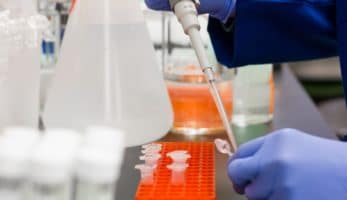 Lab technician putting medicine into vials.