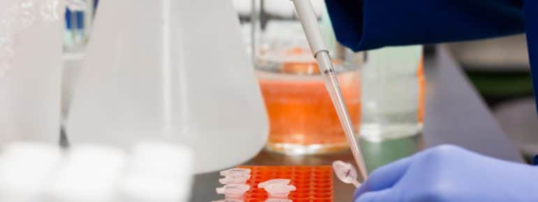 Lab technician putting medicine into vials.