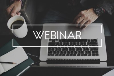 A laptop and coffee mug with the word "Webinar" over it.