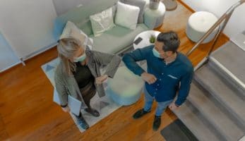 Two employees in masks, bumping elbows instead of shaking hands