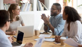 Employees talking at a desk