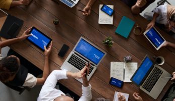 Employees at table with laptops and notebooks