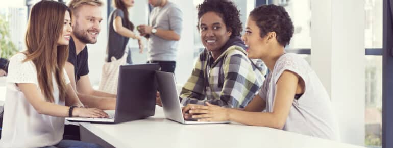 diverse employees sitting around a table discussing employee benefit packages